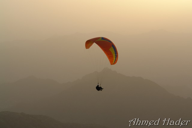 adventure parachuting over mountain near clouds