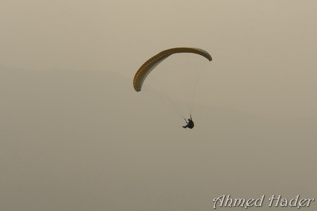 adventure parachuting over mountain near clouds