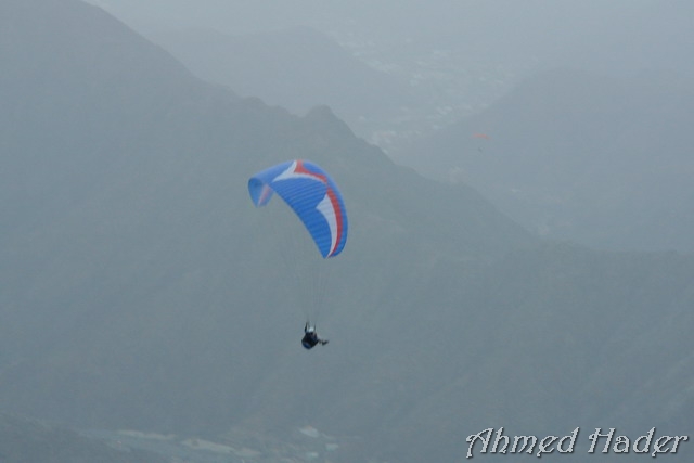 adventure parachuting over mountain near clouds